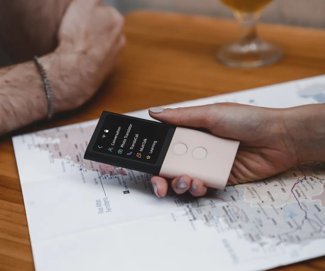 Lähikuva kädestä, joka pitelee kääntäjää pöydän päällä, jossa on kartta